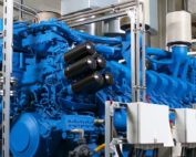 Ein großer blauer Motor mit schwarzen Kraftstofffiltern und Leitungen für die Kraftstoffzufuhr.