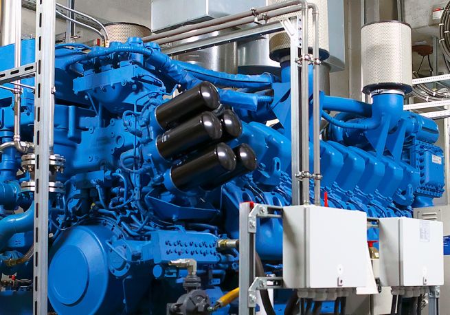 Ein großer blauer Motor mit schwarzen Kraftstofffiltern und Leitungen für die Kraftstoffzufuhr.