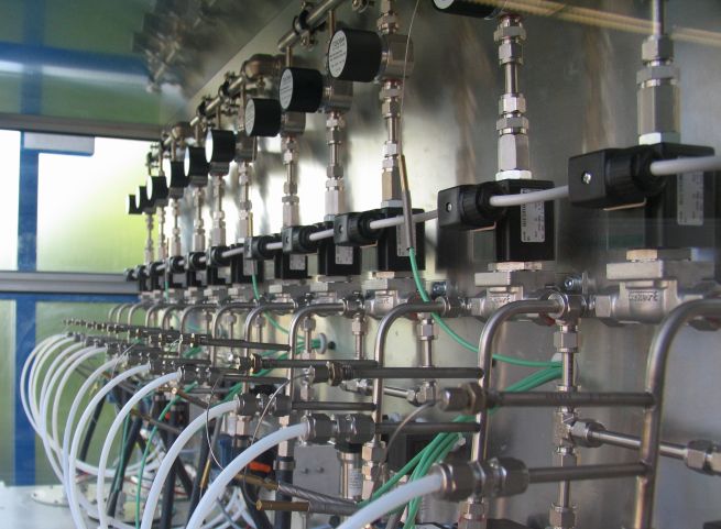 Ein Prüfstand mit hellen Kunststoffleitungen, silbernen Metallrohren und Kraftstoffpumpen.