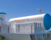 Windräder, Wasserstofftanks und Elektrolyseure vor blauem Himmel