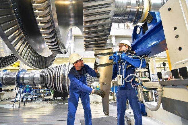 Techniker im Maschinenbau montieren eine Gasturbine.
