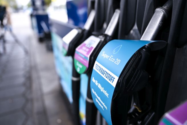 Drei Zapfpistolen an einer Zapfsäule, eine davon mit E20-Aufkleber